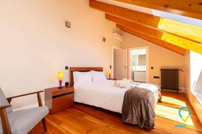 a bedroom with a large white bed and wooden floors at So Trendy Porto in Porto