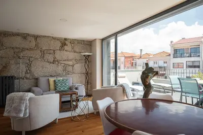 a living room with a table and a large window at So Trendy Porto in Porto