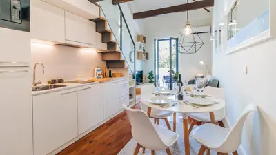 a dining room with a white table and white chairs at Terrace Pool Apartment Oporto by LovelyStay in Porto