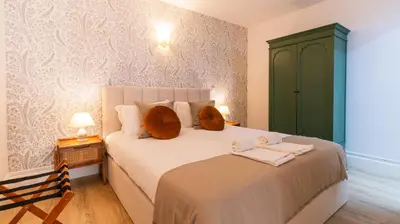 a bedroom with a large bed with a green cabinet at Urban House Marquês by LovelyStay in Porto