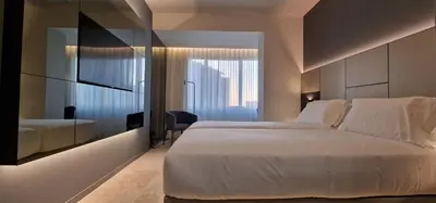 a hotel room with a bed and a mirror at Bom Sucesso Hotel by gaiarooms in Porto