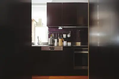 a kitchen with black cabinets and a sink at Boavista Sunlit Duplex with Terrace in Porto