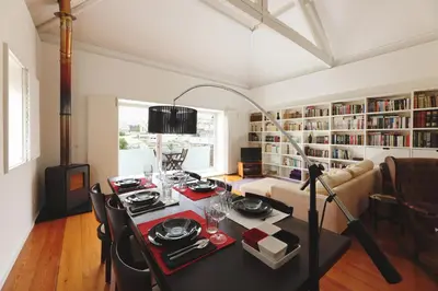 a living room with a table and a couch and a book shelf at Boavista Sunlit Duplex with Terrace in Porto