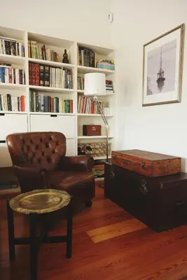 a living room with a chair and a book shelf at Boavista Sunlit Duplex with Terrace in Porto