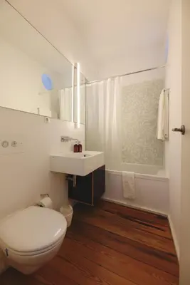 a white bathroom with a toilet and a sink at Boavista Sunlit Duplex with Terrace in Porto