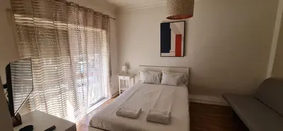 a bedroom with a bed and a large window at Constituição 1012 in Porto