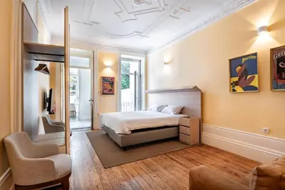 a bedroom with a bed and a chair at Downtown Grand Houses in Porto