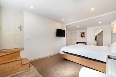 a bedroom with a bed and a tv on a wall at Downtown Grand Houses in Porto