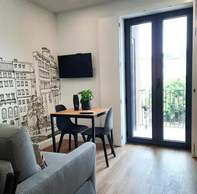 a living room with a table and chairs and a tv at Smiling Places - Apartment in Porto in Porto
