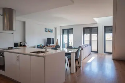 a kitchen and living room with a table and chairs at Comfy Porto in Porto