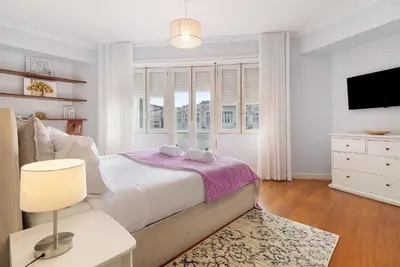 a white bedroom with a large bed and a window at Apartment Boutique Santa Catarina 1 in Porto