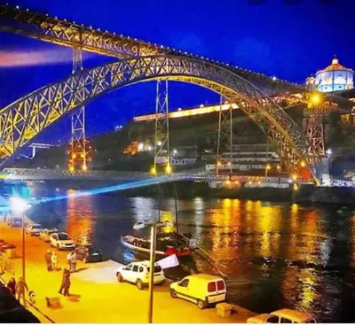 a bridge over a river at night with cars parked at Apartment Boutique Santa Catarina 1 in Porto