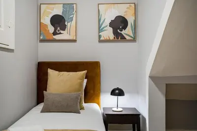 a bedroom with a bed and two pictures on the wall at GuestReady - Comendador Sto Ildefonso in Porto
