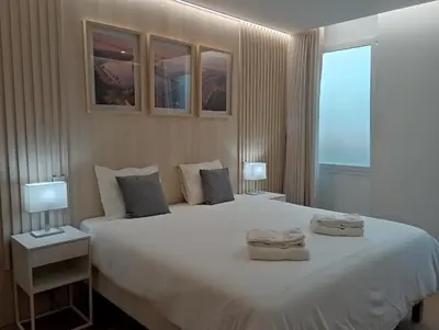 a bedroom with a large white bed with two towels on it at 714 Galé Apartment Wi-Fi in Porto