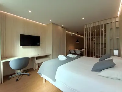 a bedroom with a bed and a desk and a television at 714 Galé Apartment Wi-Fi in Porto