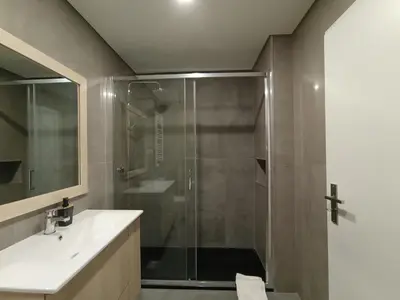 a bathroom with a glass shower and a sink at 714 Galé Apartment Wi-Fi in Porto
