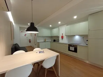 a kitchen with a wooden table and white cabinets at 714 Galé Apartment Wi-Fi in Porto