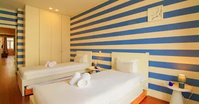 two beds in a room with blue and yellow stripes at ALIADOS by YoursPorto in Porto