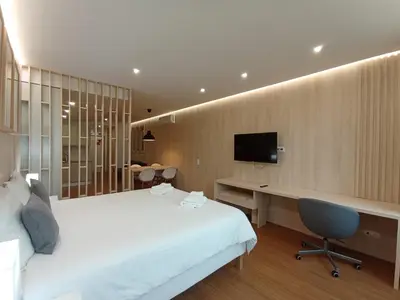 a hotel room with a bed and a desk and a television at 715 Galé Apartment Wi-Fi, Estacionamento in Porto