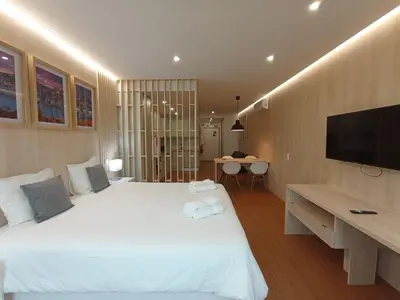 a bedroom with a large white bed with a flat screen tv at 715 Galé Apartment Wi-Fi, Estacionamento in Porto
