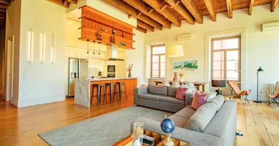 a living room with a couch and a kitchen at RIBEIRA by YoursPorto in Porto
