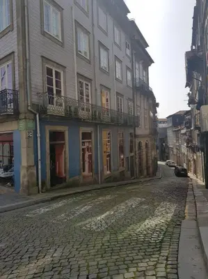 a cobblestone street in front of a large building at River Flat III - Heart of Porto in Porto