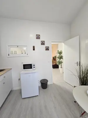 a white kitchen with a white refrigerator and a table at River Flat III - Heart of Porto in Porto
