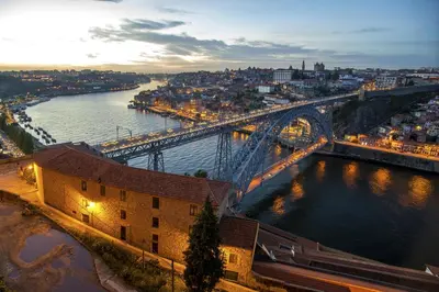 a view of a bridge over a river at night at Welcome to my city in Porto