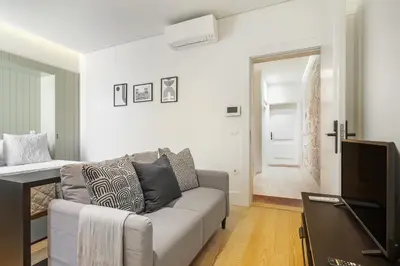 a living room with a couch and a television at WHome Timeless Luxury Porto w/ AC & Elevator in Porto