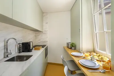 a kitchen with a sink and a table with chairs at WHome Timeless Luxury Porto w/ AC & Elevator in Porto