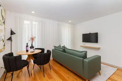 a living room with a green couch and a table at GuestReady - Cozy Vitoria Apartment in Porto