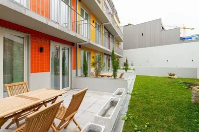 an outdoor patio with a wooden table and chairs at GuestReady - Cozy Vitoria Apartment in Porto