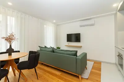 a living room with a green couch and a table at GuestReady - Cozy Vitoria Apartment in Porto