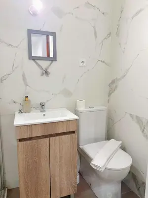 a white bathroom with a sink and a toilet at Downtown 2 minutes by walk to center and metro-direct to airpot T4 in Porto