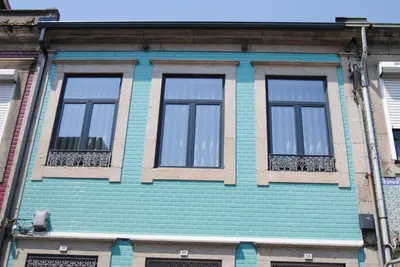 a blue building with four windows on a street at Gaia Loves You - Jardim do Morro in Vila Nova de Gaia