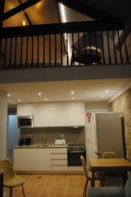 a kitchen with white cabinets and a table and chairs at Gaia Loves You - Jardim do Morro in Vila Nova de Gaia