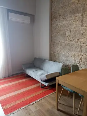 a living room with a couch and a brick wall at Gaia Loves You - Ponte D. Luis in Vila Nova de Gaia