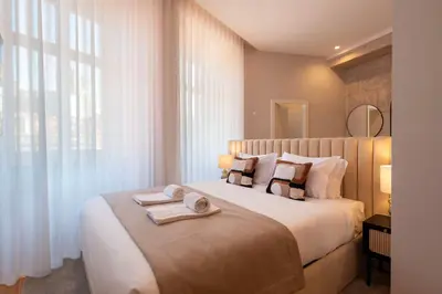 a bedroom with a large bed with towels on it at Ando Living - Flores 200 House in Porto