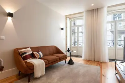 a living room with a brown couch and windows at Ando Living - Flores 200 House in Porto