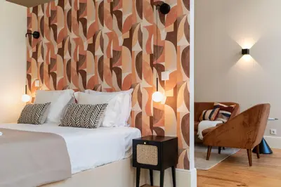 a bedroom with a bed and a wall with a pattern at Ando Living - Flores 200 House in Porto