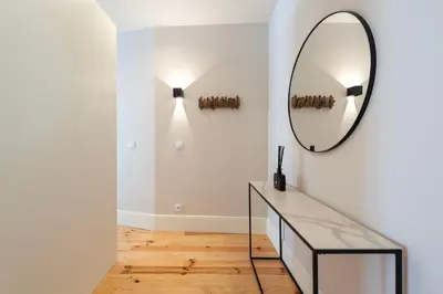a mirror on a wall in a room with a table at Ando Living - Flores 200 House in Porto