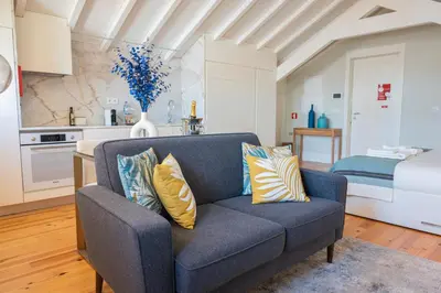 a blue couch in a living room with a bed at Nautical Luxury Loft in Porto
