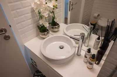 a bathroom counter with a sink and flowers on it at Nautical Luxury Loft in Porto