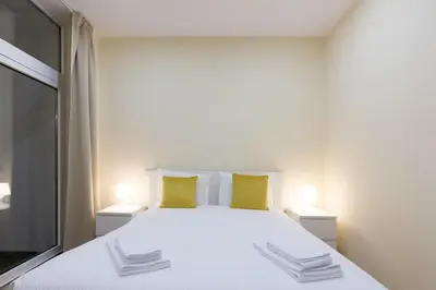 a bedroom with a large white bed with yellow pillows at OPO Santa Catarina in Porto