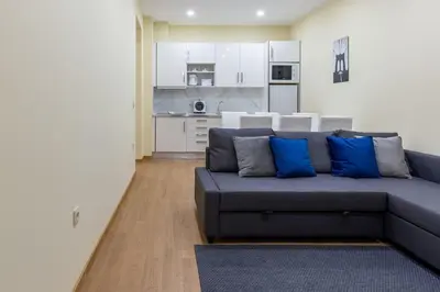 a living room with a blue couch and a kitchen at OPO Santa Catarina in Porto