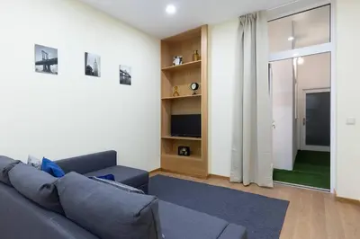 a living room with a gray couch and a tv at OPO Santa Catarina in Porto