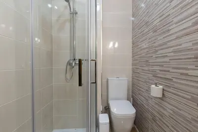 a bathroom with a toilet and a glass shower at OPO Santa Catarina in Porto