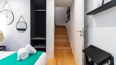 a small apartment with a green bed and a staircase at Premium 2BR Flat near Santa Catarina by LovelyStay in Porto