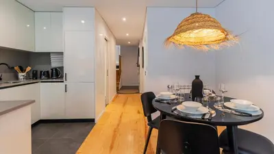 a kitchen and dining room with a table and chairs at Premium 2BR Flat near Santa Catarina by LovelyStay in Porto