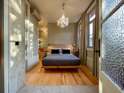 a bedroom with a bed and a chandelier at Victoria House in Porto